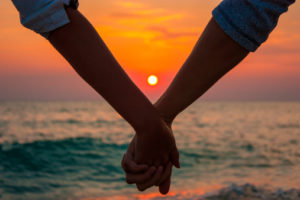 Couple Holding Hands at Sea Sunset